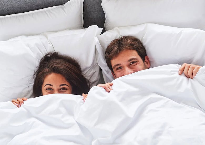 couple happy and in bed looking cosy